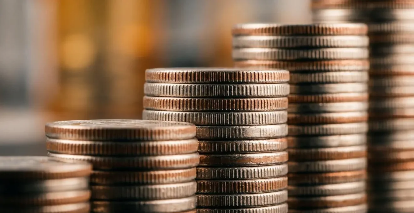 Vue macro de pièces empilées symbolisant l'équilibre entre salaire et dividendes
