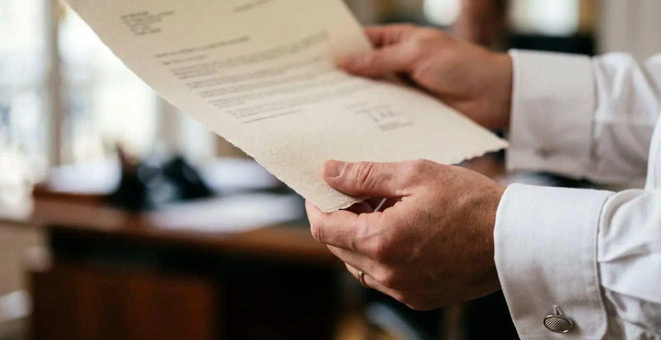 Mains professionnelles tenant un document de teaser commercial avec contenu flouté